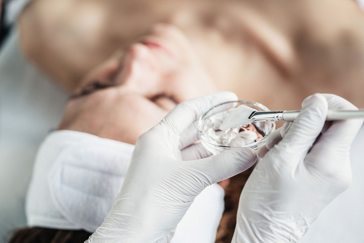 Nærbilde av kvinne som får en kjemisk peeling behandlig med Elixir Face formula produkter