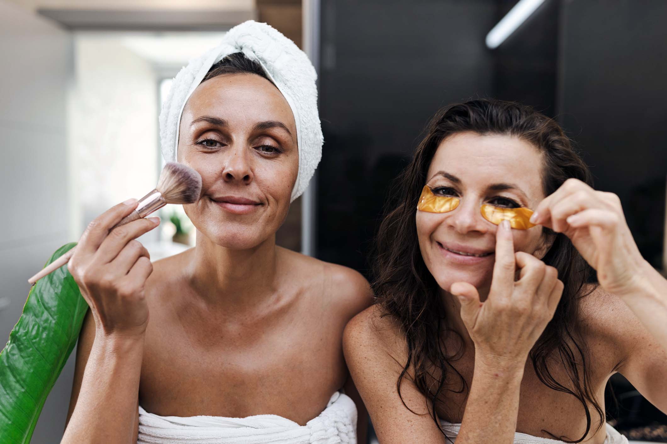 To kvinner i førtiårene som steller huden sammen